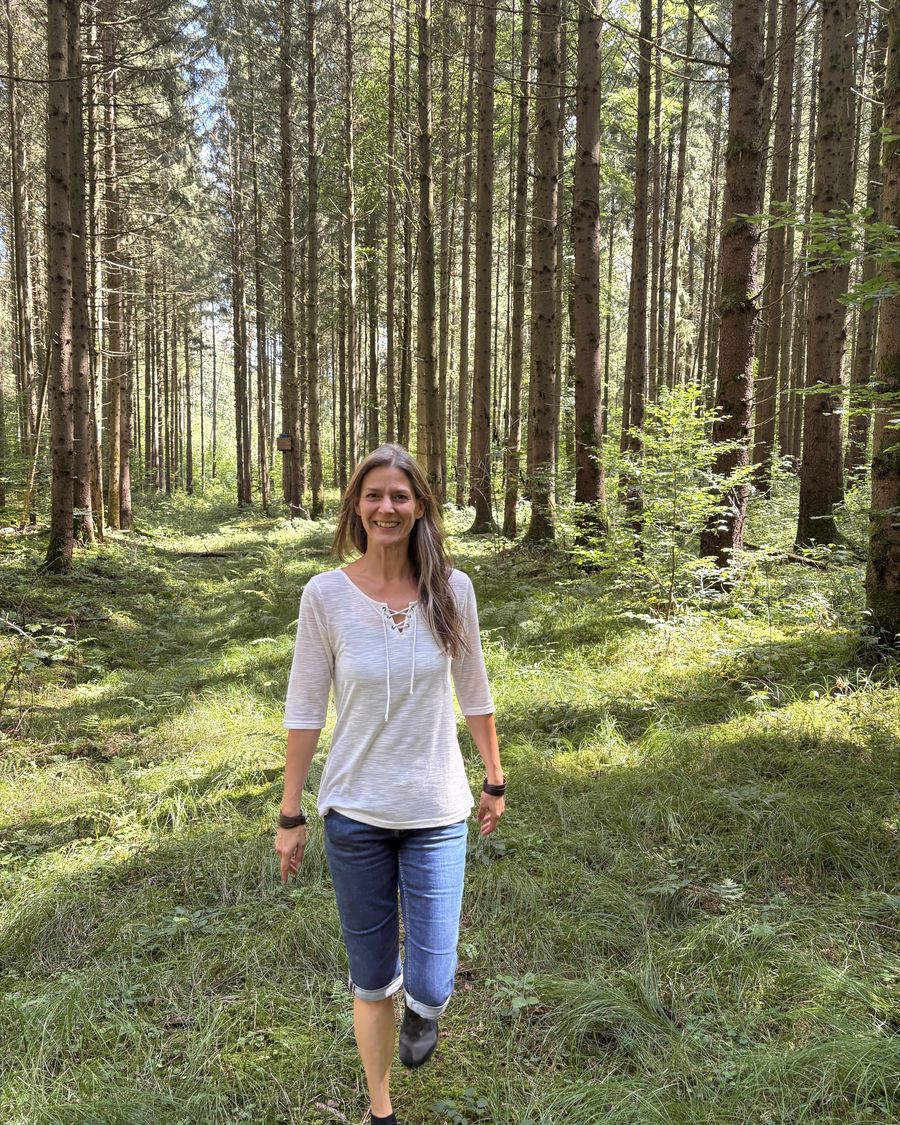 Kathleen Schütz geht durch einen lichten Wald